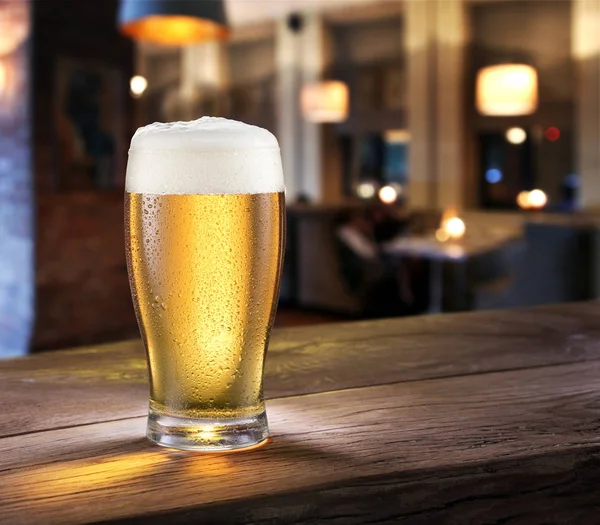 Bicchiere ghiacciato di birra leggera sul bancone del bar . — Foto Stock