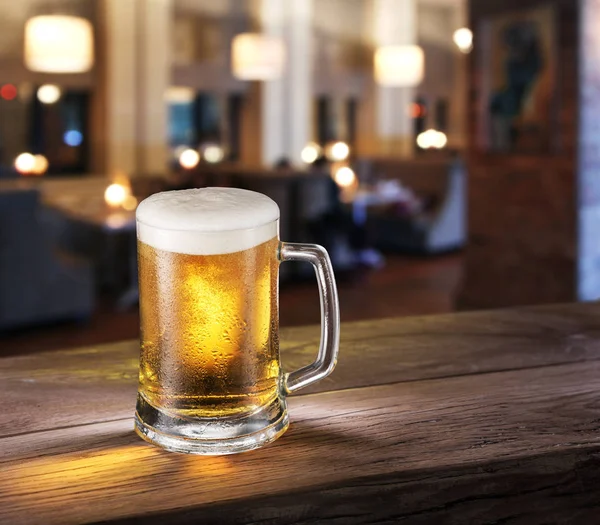 Orosená sklenice lehkého piva na panelu čítačů. — Stock fotografie