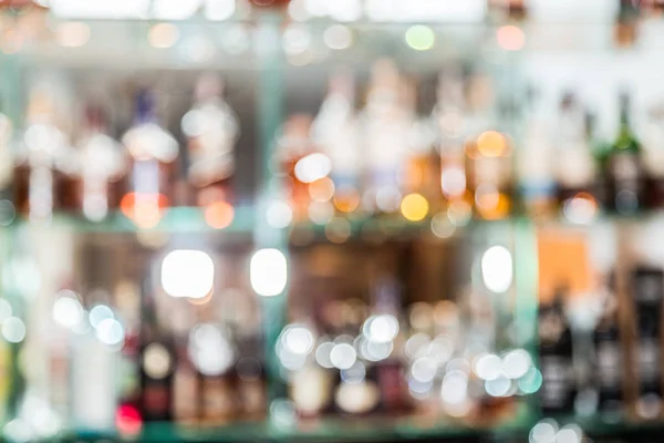 Πολύχρωμα μπουκάλια στα ράφια του μπαρ. Θολή φόντο. — Φωτογραφία Αρχείου