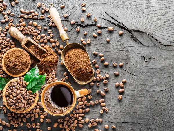 Roasted coffee beans, ground coffee and cup of coffee on wooden — Stock Photo, Image