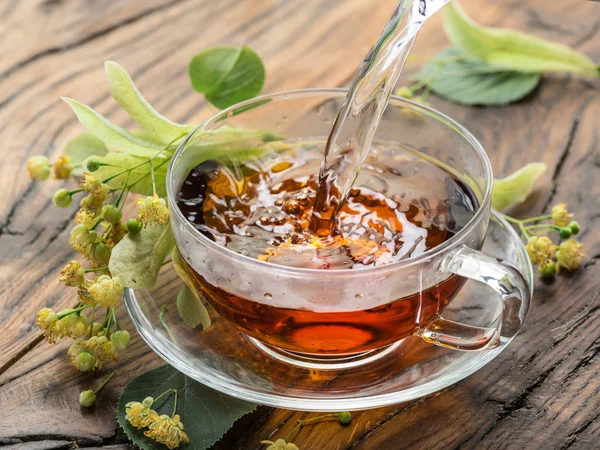 Secangkir teh linden dan bunga kapur di meja kayu . — Stok Foto