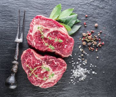 Kaburga biftek siyah arka plan üzerine baharat ile. 