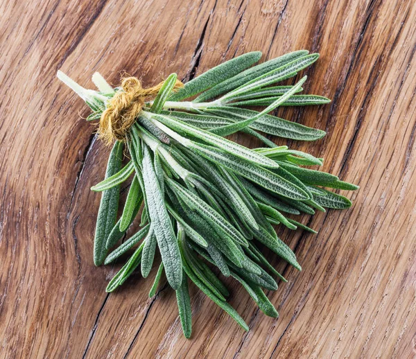 Bunch of rosemary herb on the wooden table.