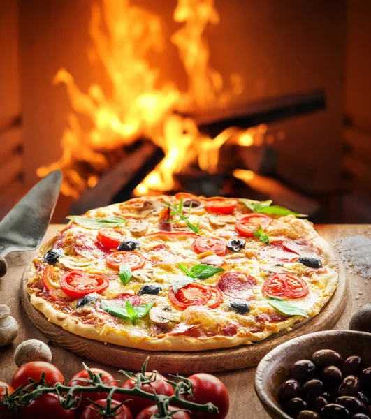 Pizza. Hout gestookte oven op de achtergrond. — Stockfoto