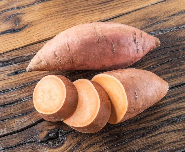 Batatas doces na velha mesa de madeira. — Fotografia de Stock