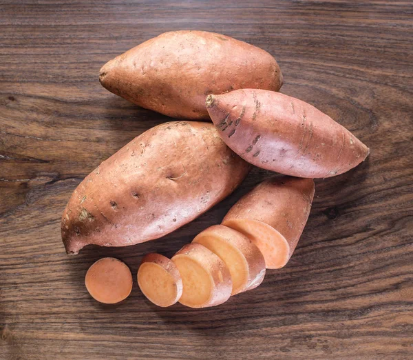 Sweet potatoes on the old wooden table. — Stock Photo, Image