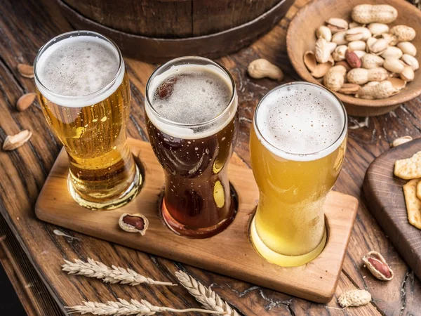 Biergläser und Snacks auf dem Holztisch. — Stockfoto