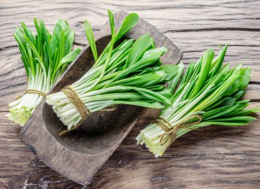 Ahşap masa üzerinde genç taze yabani sarımsak.