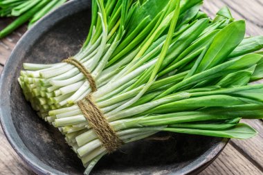 Ahşap masa üzerinde genç taze yabani sarımsak.