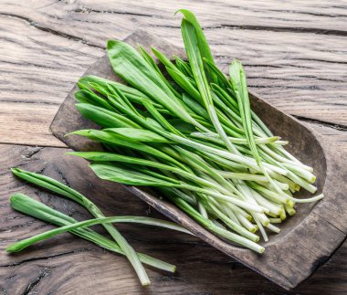 Ahşap masa üzerinde genç taze yabani sarımsak.