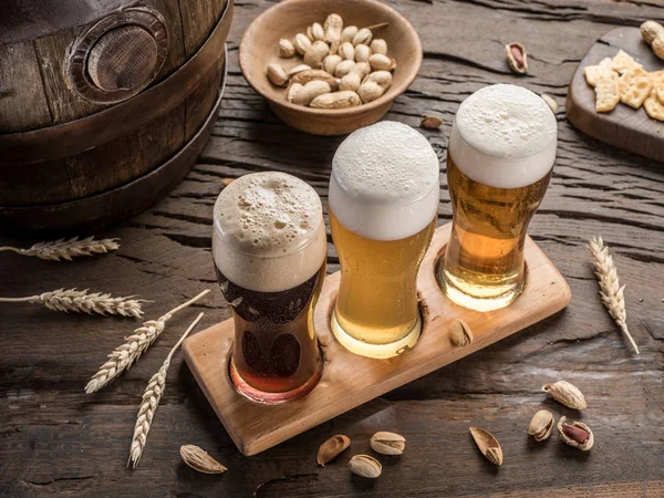 Glasses of beer and snacks on the wooden table. — Stock Photo, Image
