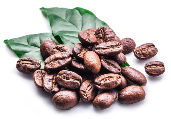 Geröstete Kaffeebohnen und Blätter auf weißem Hintergrund. — Stockfoto
