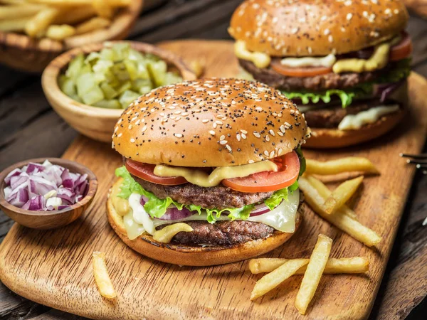 Hamburguesas y papas fritas en la bandeja de madera. — Foto de Stock