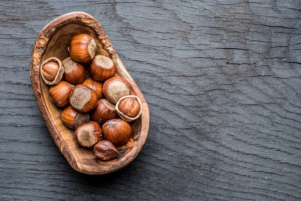 Filberts ou avelãs na tigela de madeira na mesa . — Fotografia de Stock