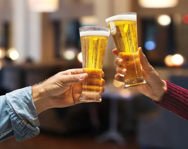 Copos de cerveja levantados num brinde. Close-up mãos com óculos . — Fotografia de Stock