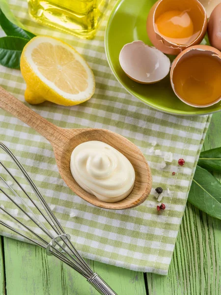 Natural mayonnaise sauce in the wooden spoon and its ingredient — Stock Photo, Image