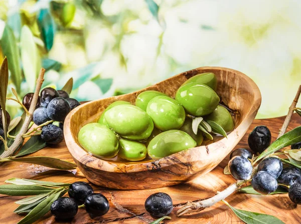 Olive da tavola intere nella ciotola di legno sul tavolo . — Foto Stock