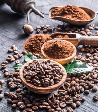 Kavrulmuş kahve çekirdekleri ve ahşap masa üzerinde çekilmiş kahve. Top vie