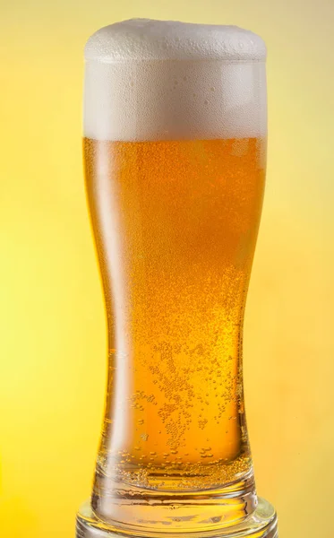 Glas bier op de gele achtergrond. — Stockfoto