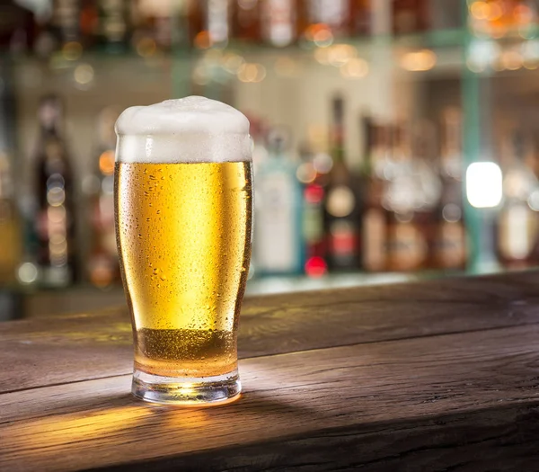 Copo gelado de cerveja leve no balcão do bar . — Fotografia de Stock