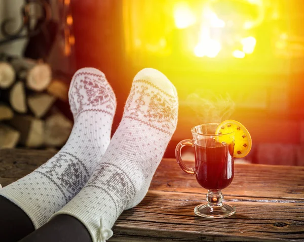 Aquecimento e relaxamento perto da lareira com uma xícara de vinho quente . — Fotografia de Stock