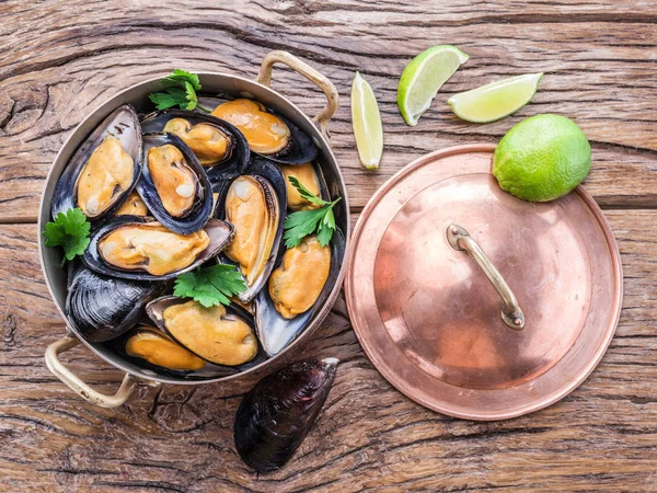 Mejillones en bandeja de cobre sobre la mesa de madera . — Foto de Stock