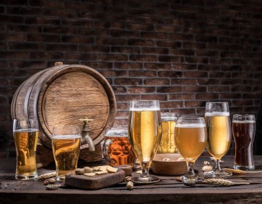 Ahşap masa üzerinde varil bira ve bira gözlük. Zanaat bira