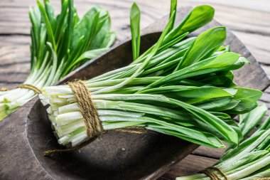Ahşap masa üzerinde genç taze yabani sarımsak.