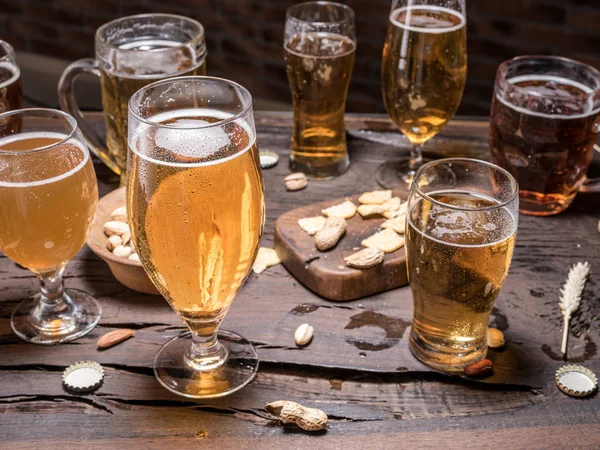 Verres de bière et snacks sur la table en bois . — Photo