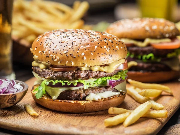 Hamburgers en frietjes op het houten dienblad. — Stockfoto