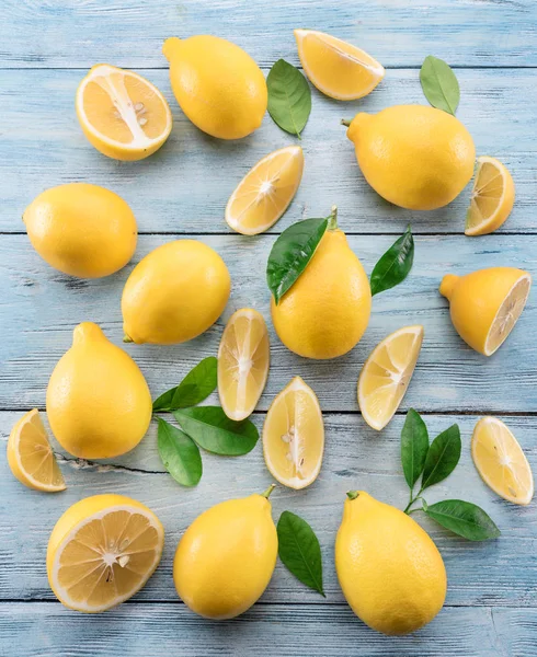 Olgun limon ve limon mavi ahşap arka plan üzerinde bırakır. Üstten Görünüm