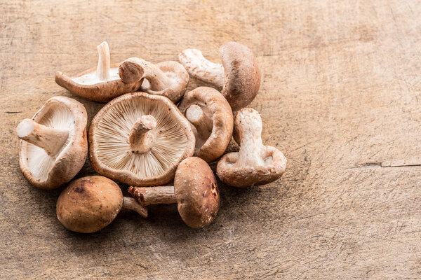 Shiitake mushrooms on the wooden background.