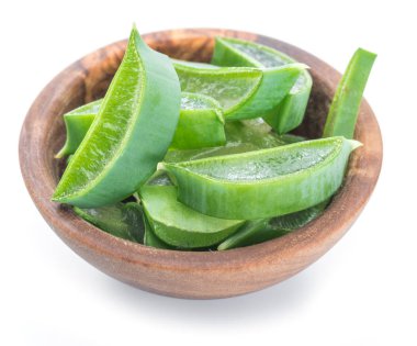Beyaz arka plan üzerinde ahşap kase taze aloe vera dilimleri.