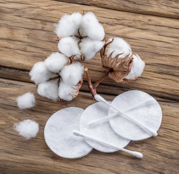 Bola de algodão macio e cotonetes e almofadas de algodão na mesa de madeira . — Fotografia de Stock