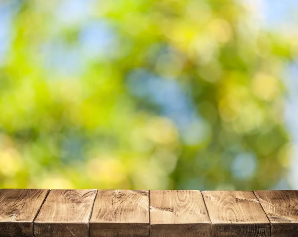 Oude houten tafel boven- en groene gebladerte op de achtergrond. — Stockfoto