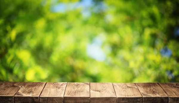 Gamla trähus tabell top och gröna bladverk i bakgrunden. — Stockfoto
