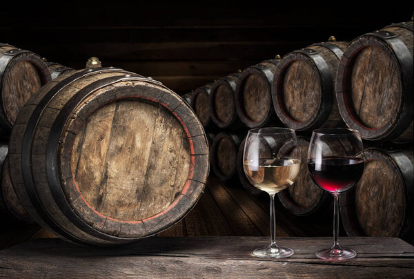 Wine barrel  and two wine glasses on the old wooden table. 