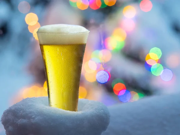 Vaso de cerveza con luces mágicas de Navidad al fondo . —  Fotos de Stock