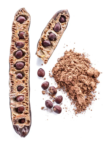 Carob pods och carob pulver på den vita bakgrunden. — Stockfoto