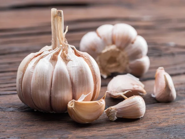 Garlic bulb and garlic cloves on the wooden table. — Stock Photo, Image