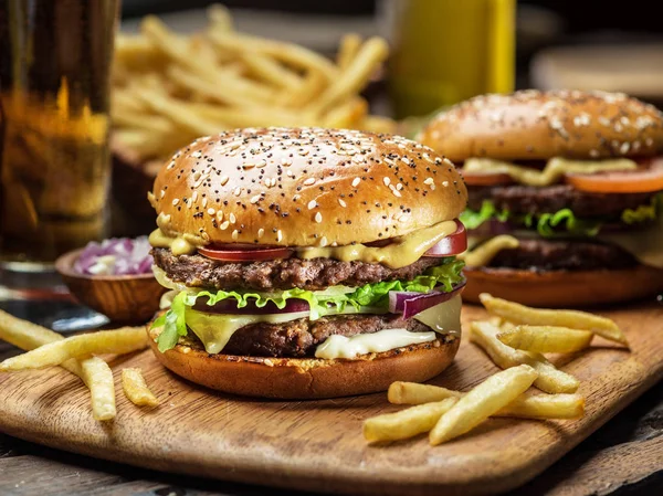 Hamburguesas y papas fritas en la bandeja de madera. — Foto de Stock