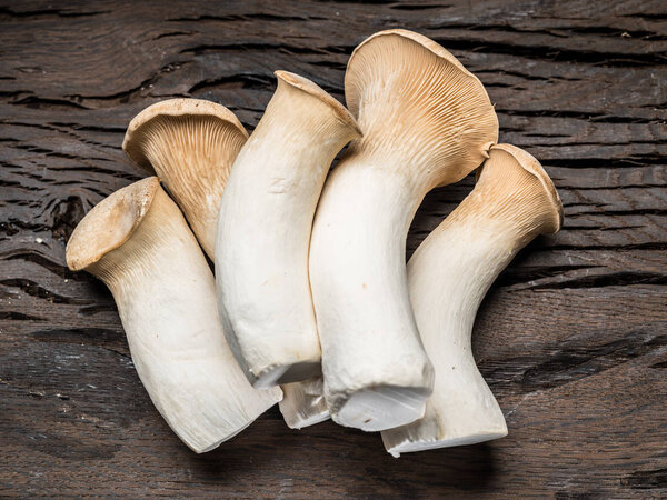 King oyster mushrooms on the wooden background.
