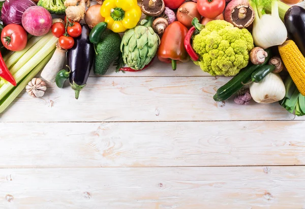 Diferentes vegetais coloridos dispostos como uma moldura. Retrocesso de madeira — Fotografia de Stock