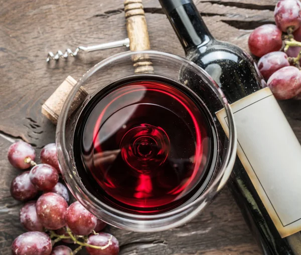 Bicchiere di vino, bottiglia di vino e uva su sfondo di legno. Vino ta — Foto Stock