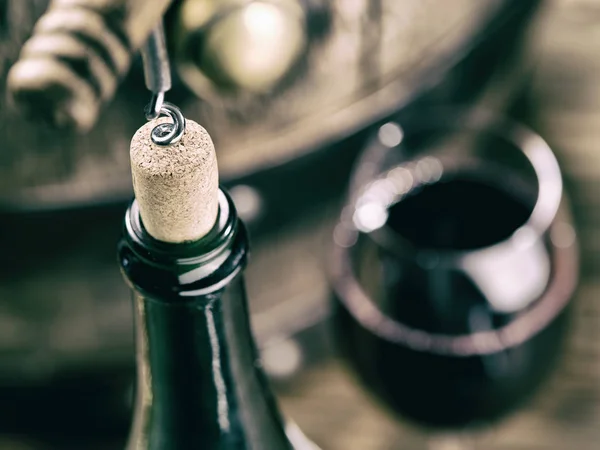 Opening wine bottle. Oak wine keg at the background. — Stock Photo, Image