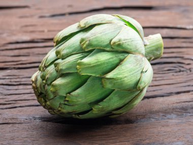 Ahşap arka plan üzerinde küre enginar bud.