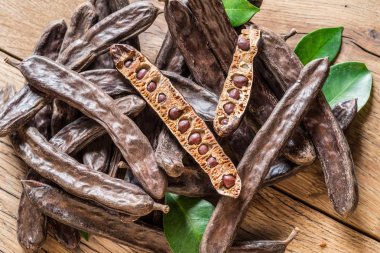 Keçiboynuzu bakla ve ahşap masa keçiboynuzu fasulye.