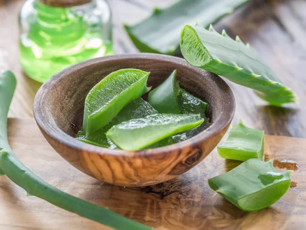 Fresh aloe leaves and aloe gel in the cosmetic jar on wooden tab — Stock Photo, Image