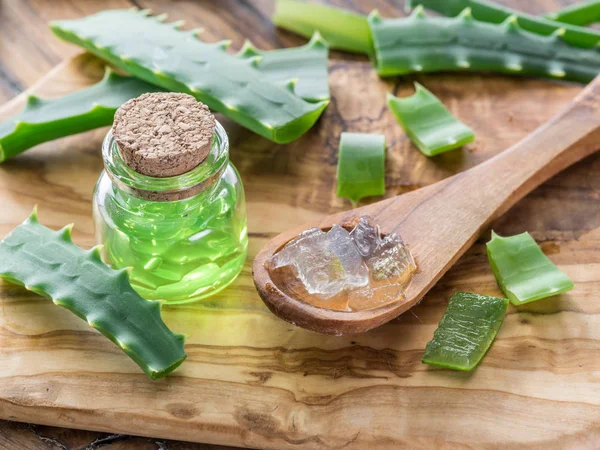 Fresh aloe leaves and aloe gel in the cosmetic jar on wooden tab — Stock Photo, Image