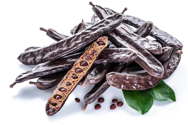 Carob 콩 깍 지와 흰색 배경에 carob 파우더. — 스톡 사진